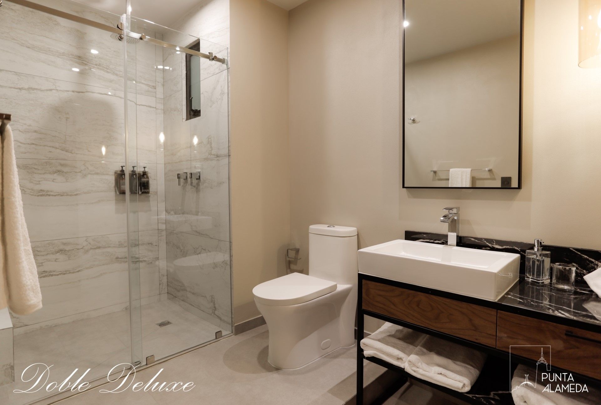 Un baño con inodoro, lavabo, espejo y ducha.
