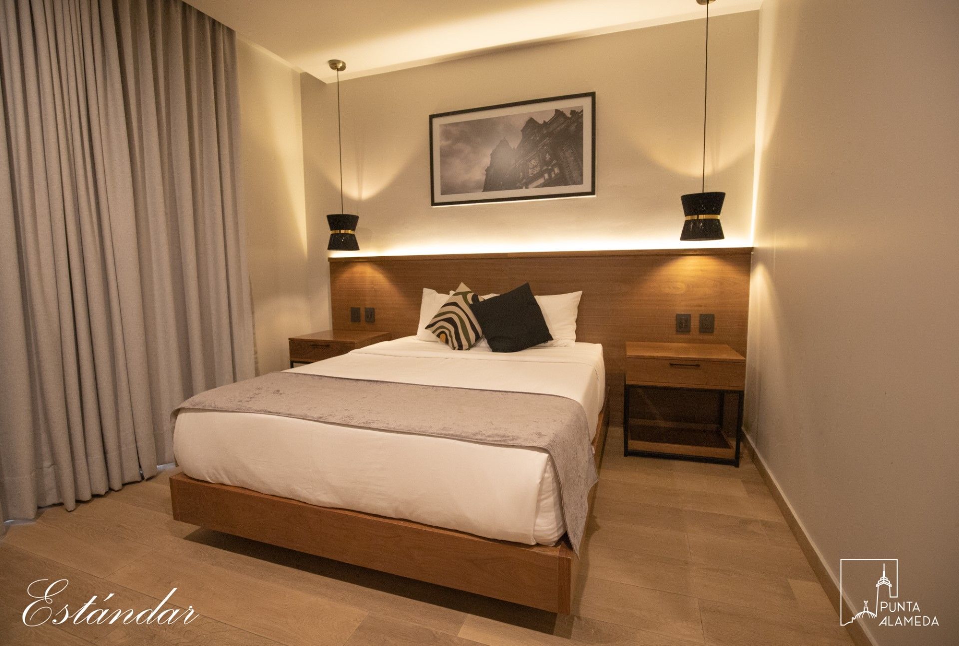 Una habitación de hotel con una cama grande y dos mesitas de noche.