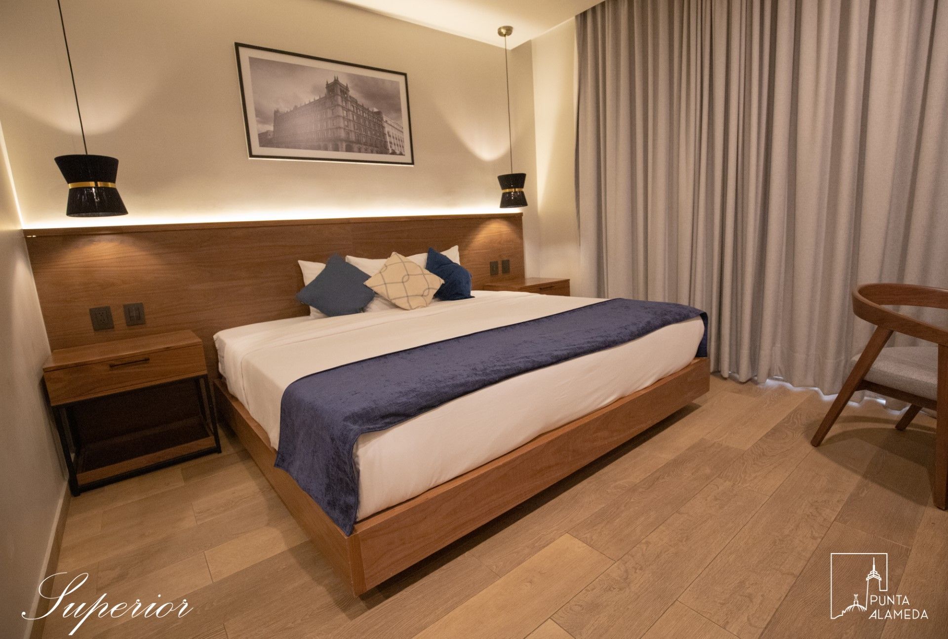 Una habitación de hotel con una cama grande y un cuadro en la pared.