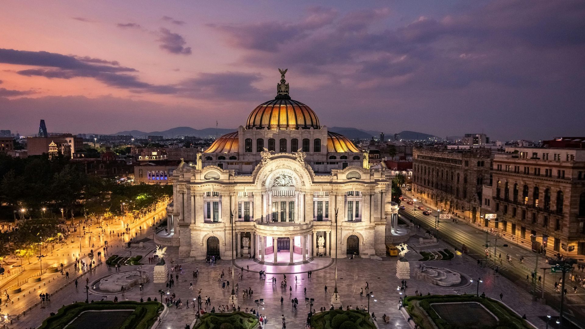 Un gran edificio con una cúpula en la parte superior se ilumina por la noche.