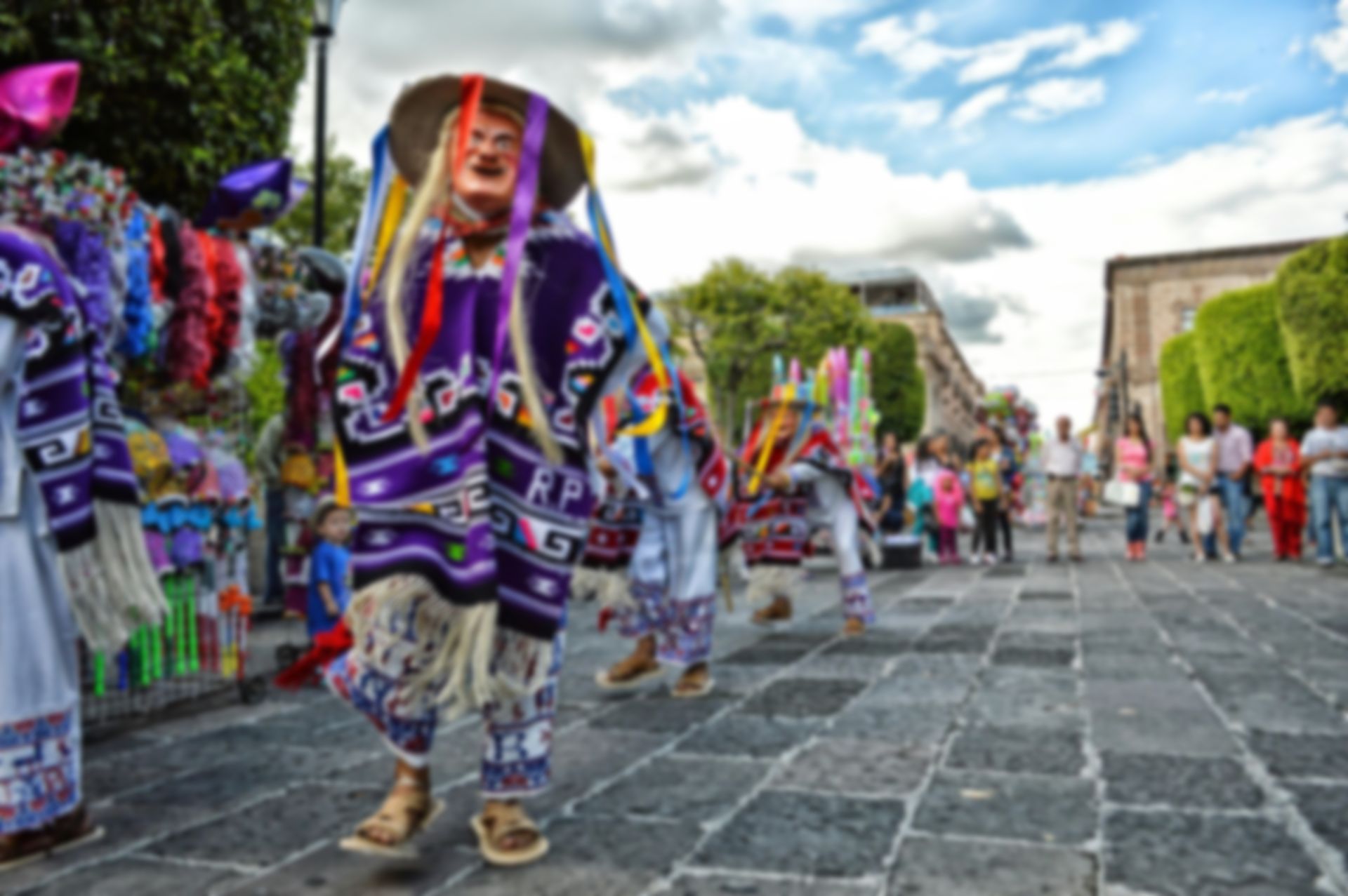 Un grupo de personas con disfraces coloridos caminan por una calle.
