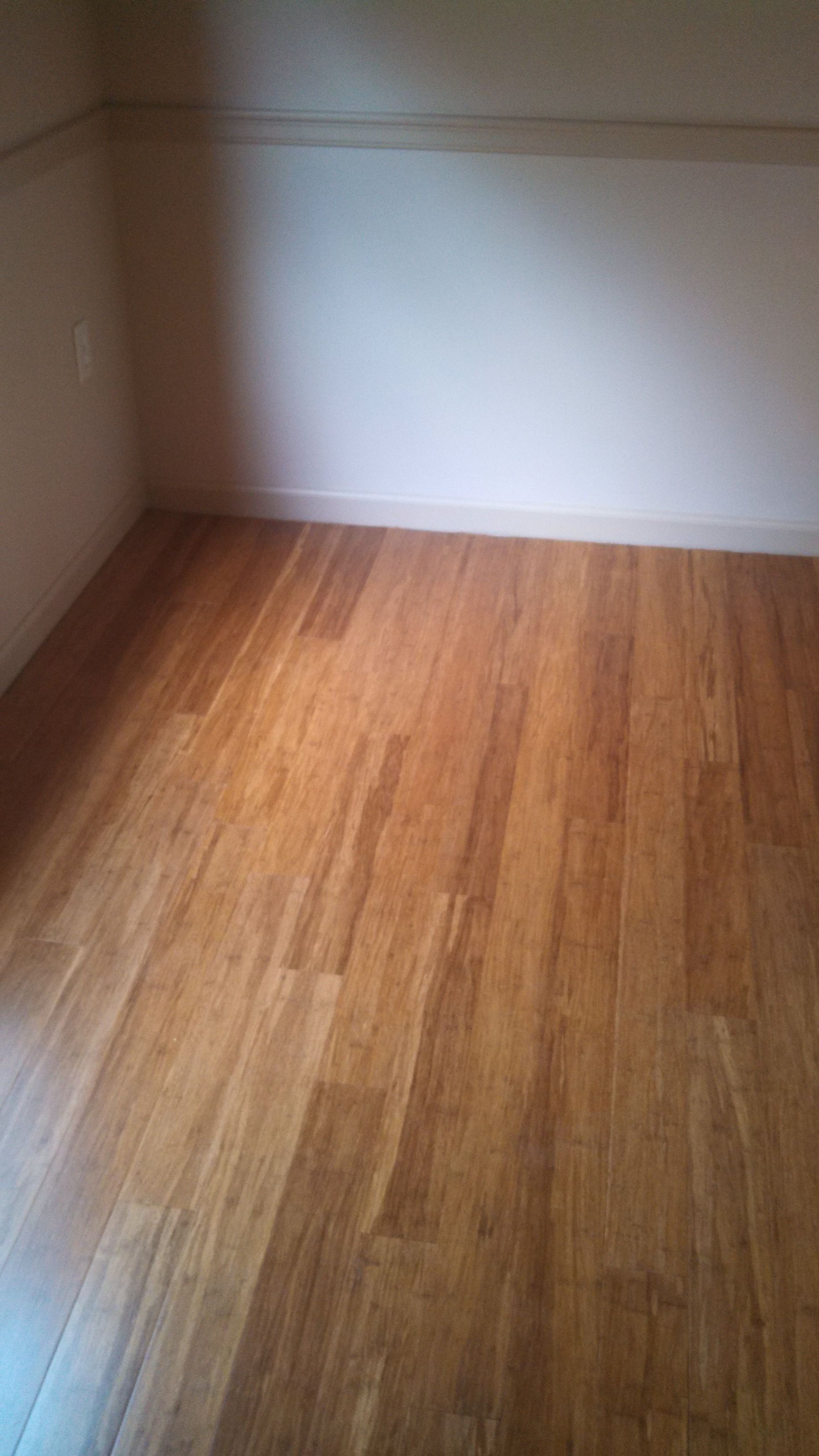 An empty room with a wooden floor and white walls.