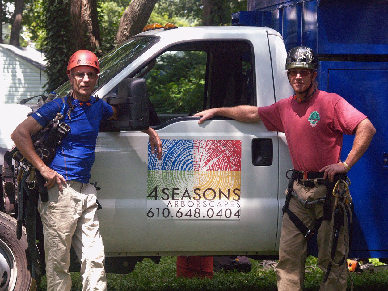 Two people standing in front of a 4 seasons truck