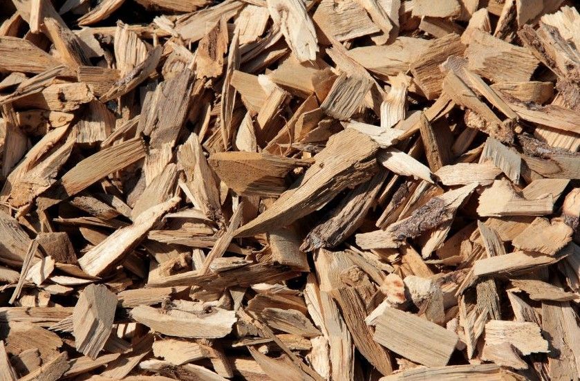 a pile of brown mulch is sitting on the ground .