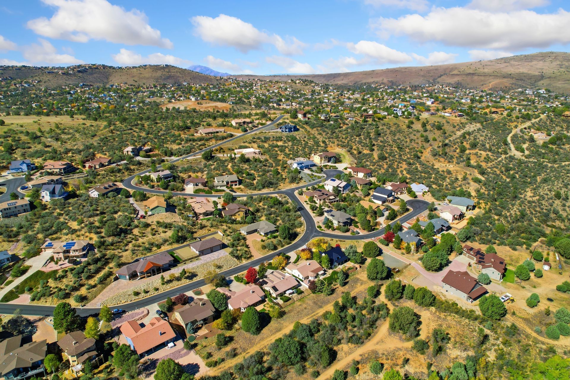 A panoramic view of a scenic hillside community and mountainous backdrop. A panoramic view of a scenic hillside community and mountainous backdrop.
