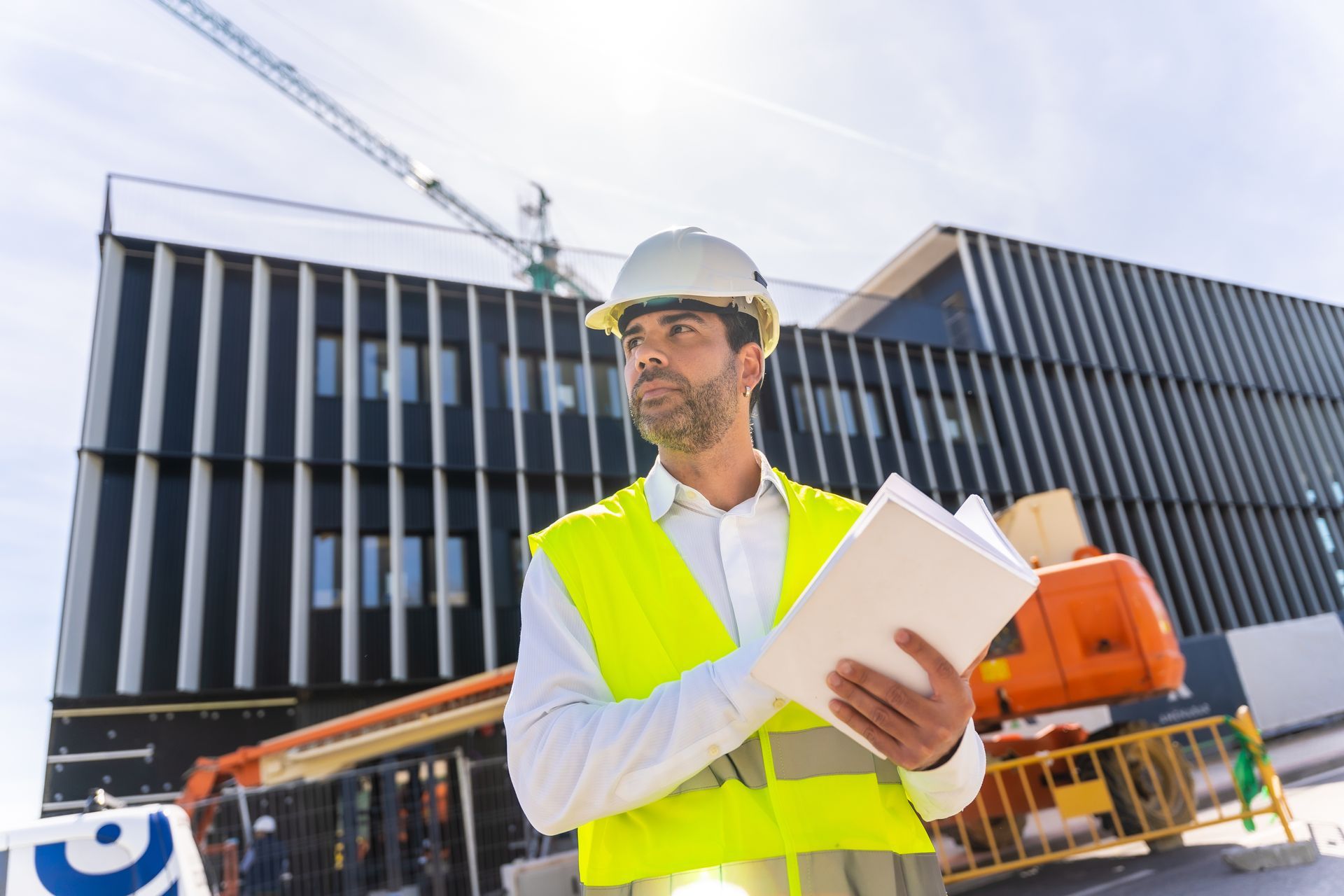 Construction manager next to the building under construction.