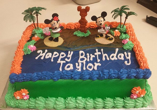 Mickey Mouse birthday cake with “Happy Birthday Taylor” icing, green frosting, and palm tree decorations