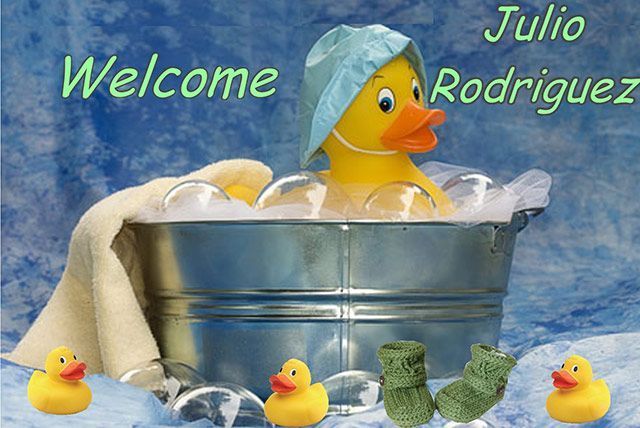 Welcome sign with a yellow duck in a metal tub, surrounded by small ducks and towels; text reads “Julio Rodriguez”
