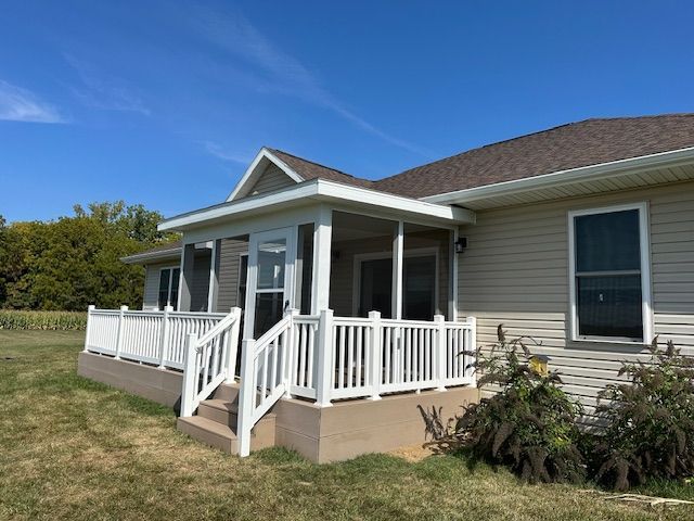 A house with a porch and a white fence