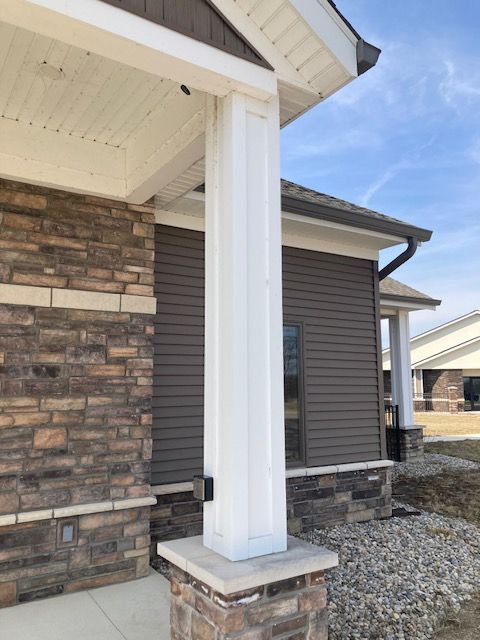 A brick house with a white pillar in front of it