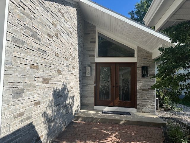 A house with a stone wall and a wooden door