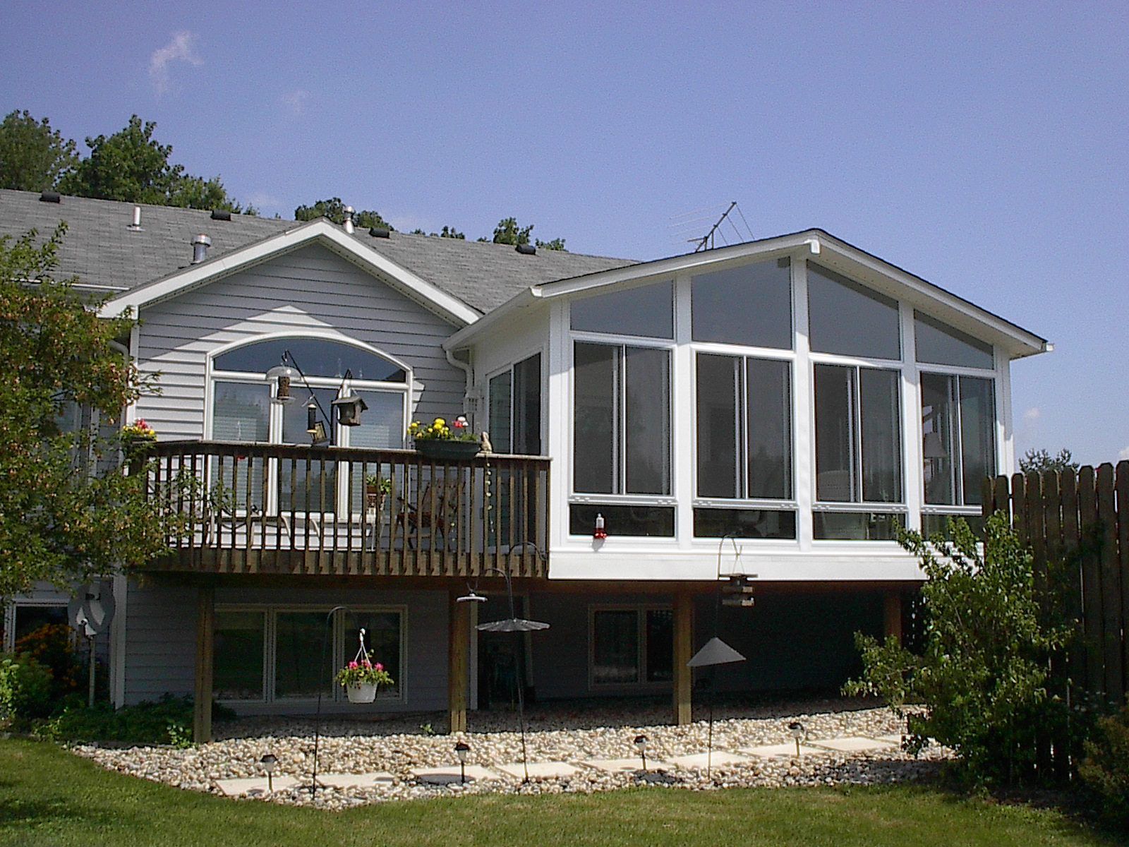A house with a large sunroom and a deck