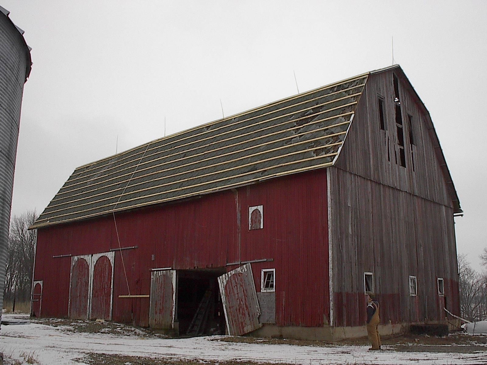 A red barn with a silo in the background