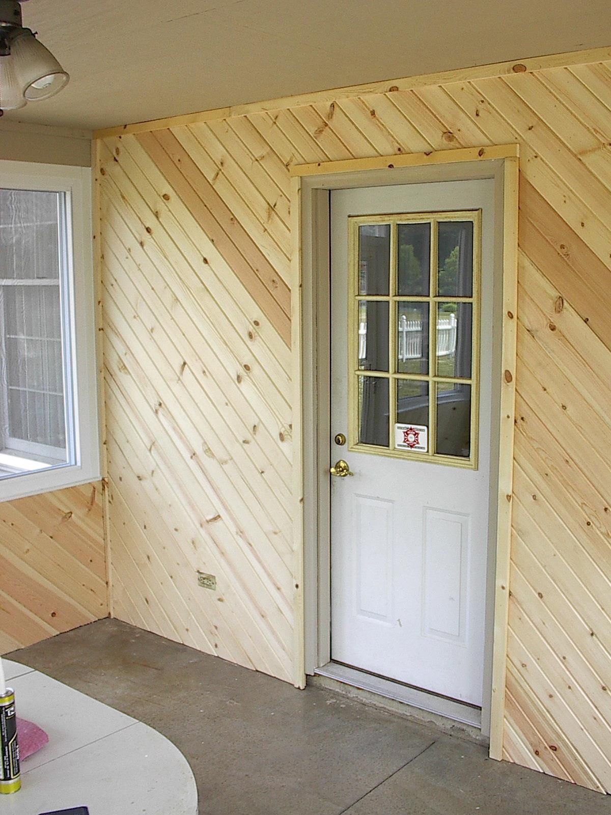 A room with wood paneling and a white door