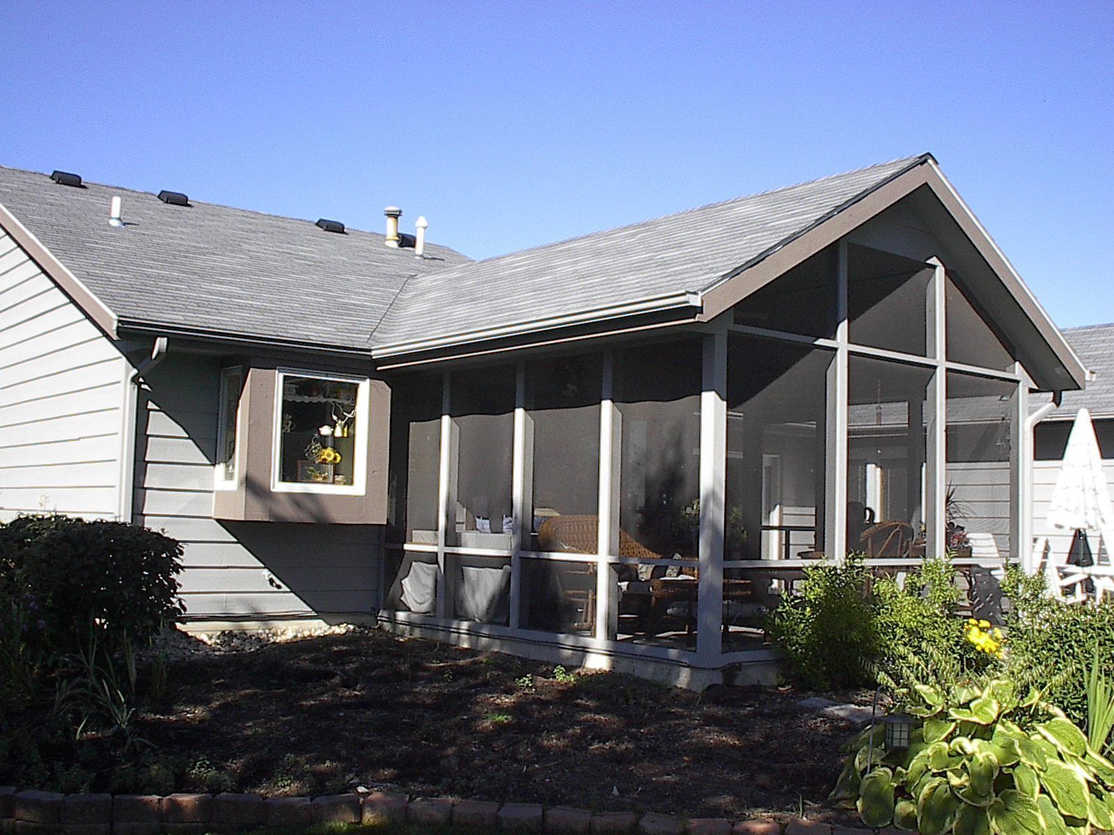 A house with a screened in porch and a window
