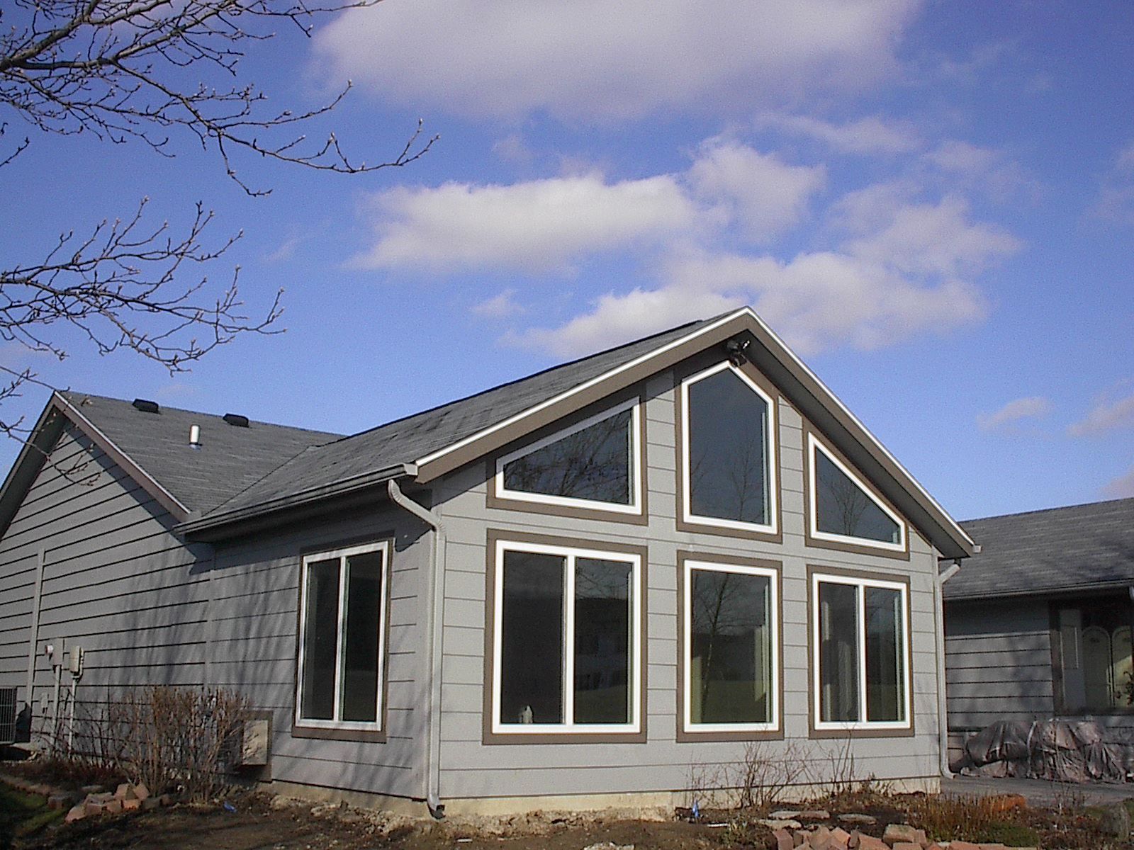 A house with a lot of windows and a blue sky in the background