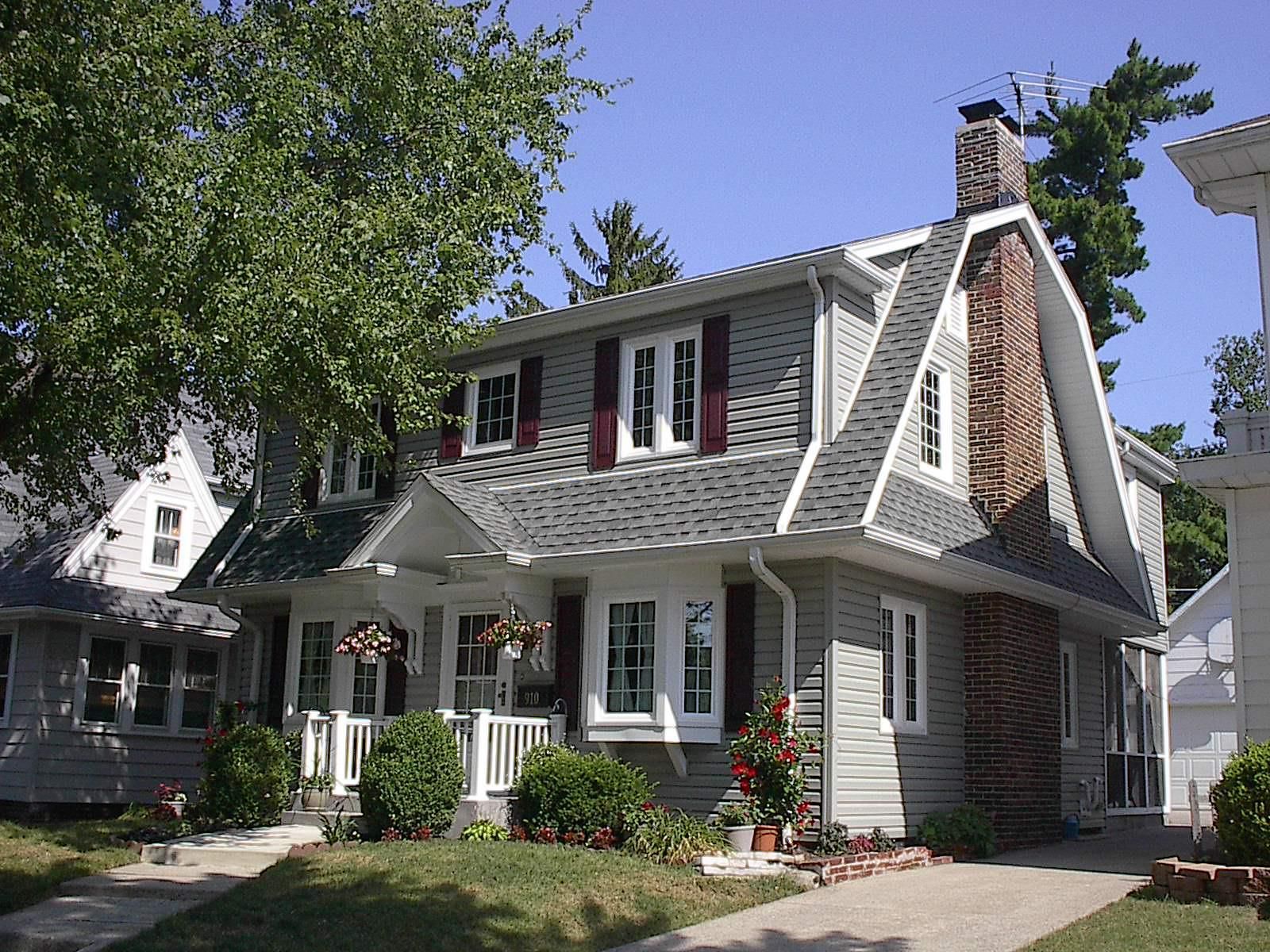 A house with a gray roof and red shutters