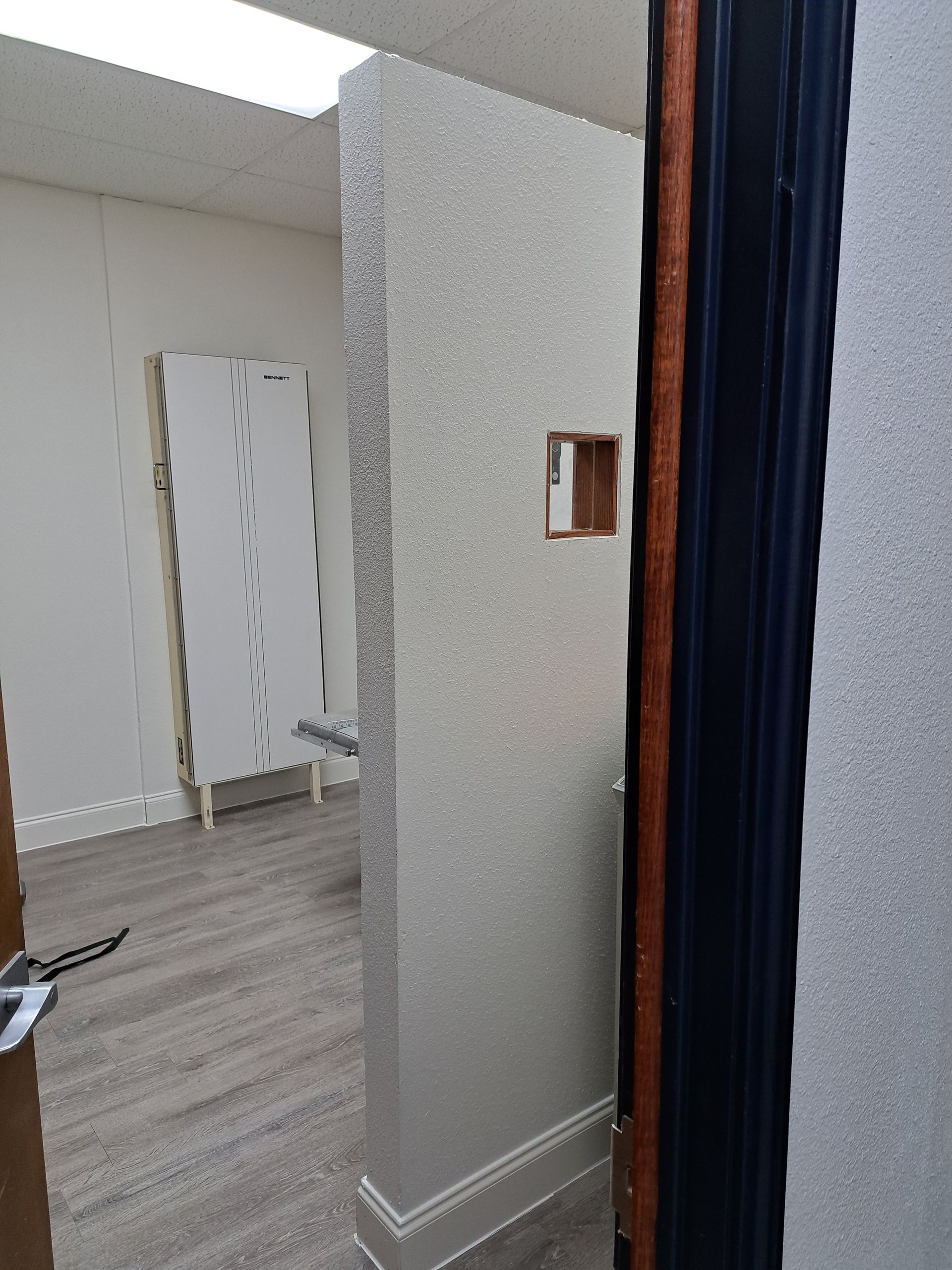 Interior doorway to room with silver glitter wall and white door.