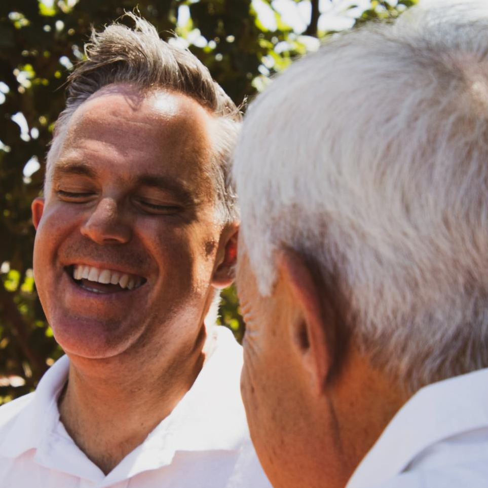 Adult man laughing with his aging father