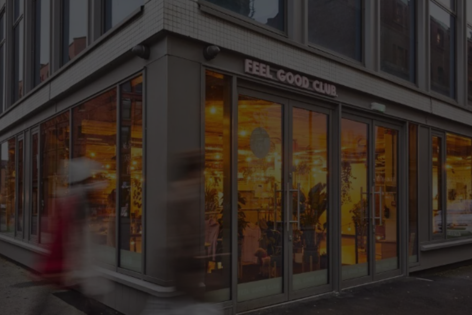 A blurry picture of a store front with a person walking in front of it.