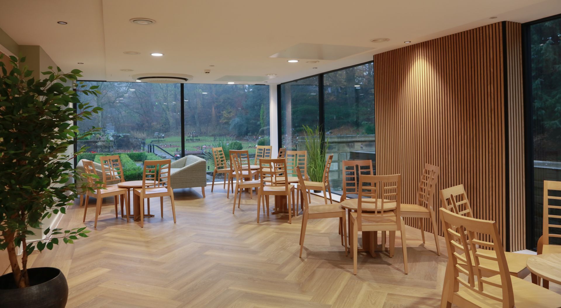 A large room with tables and chairs and a large window.