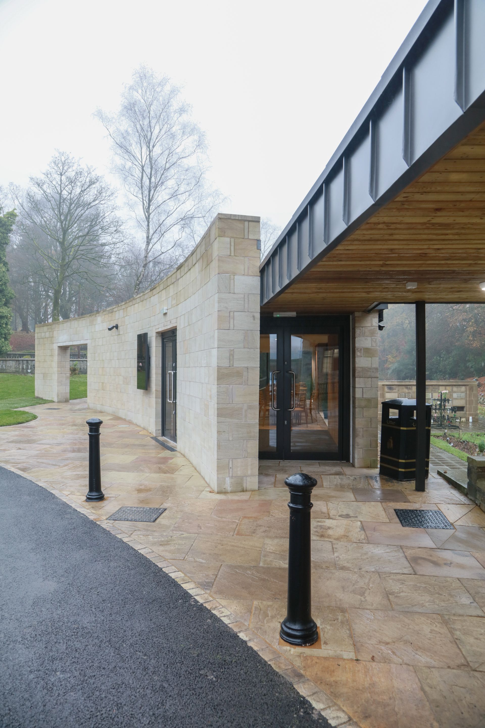 A brick building with a wooden roof and a glass door.
