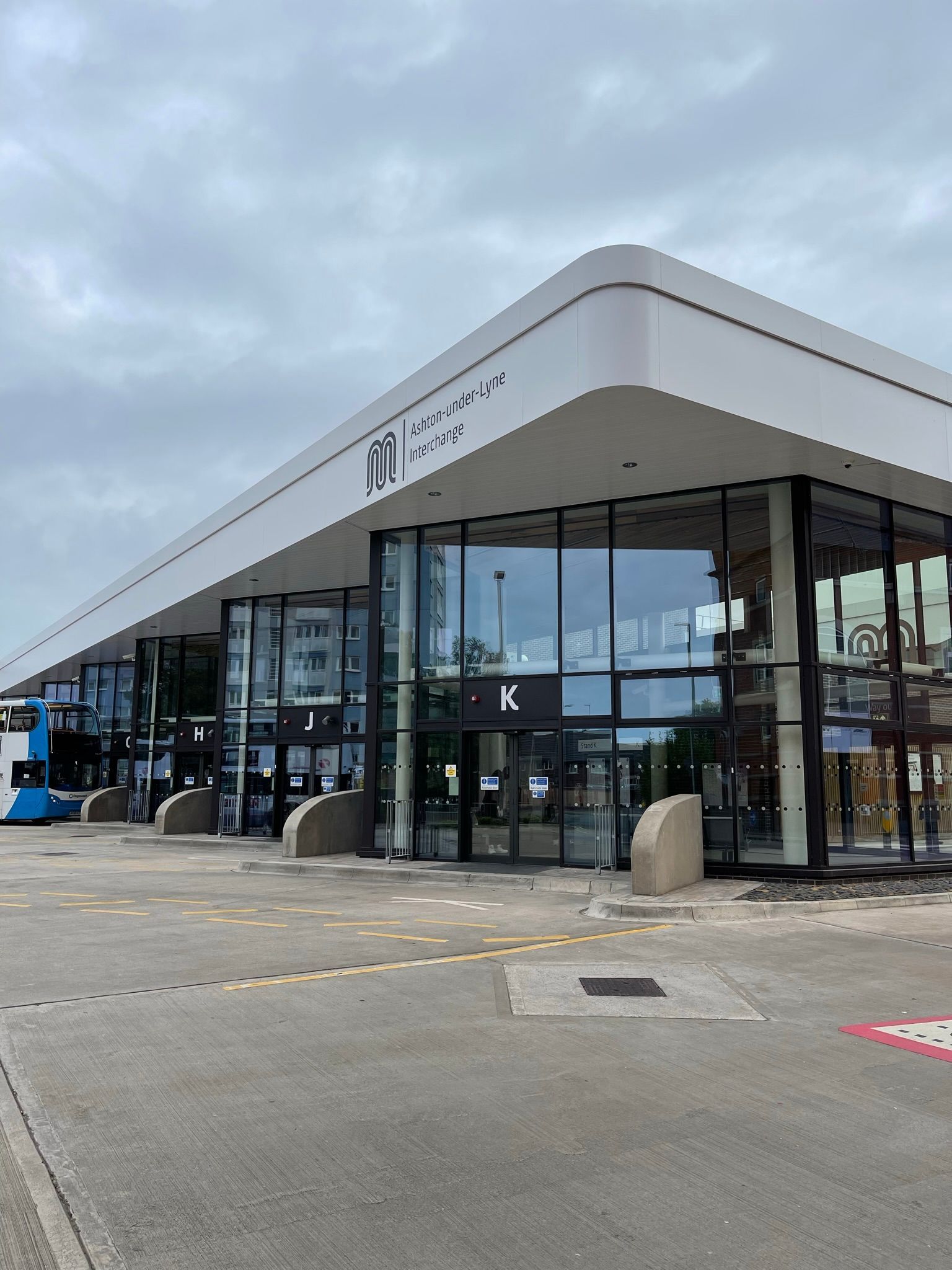 A large building with a lot of windows and a lot of cars parked in front of it.