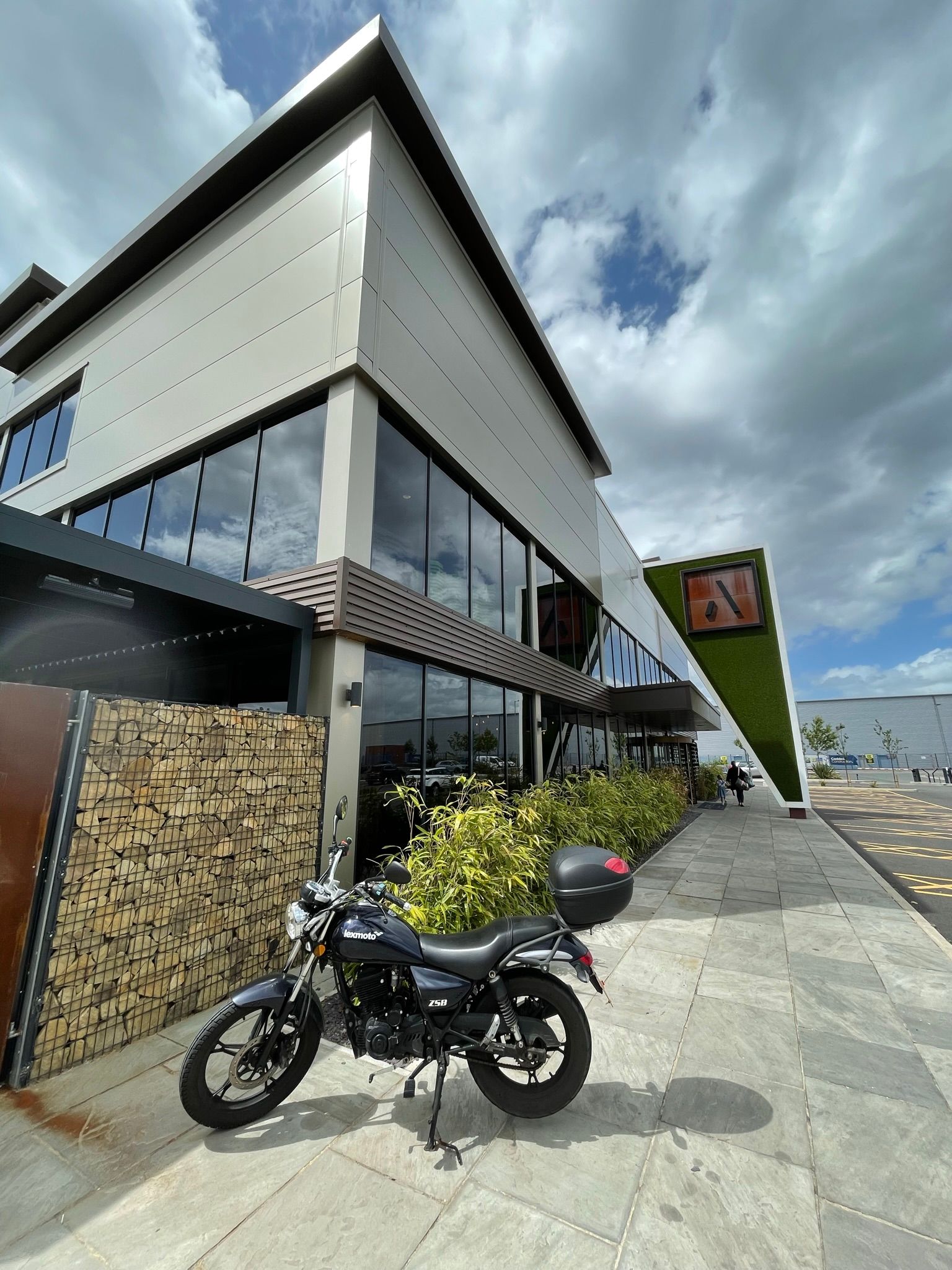 A motorcycle is parked in front of a large building.