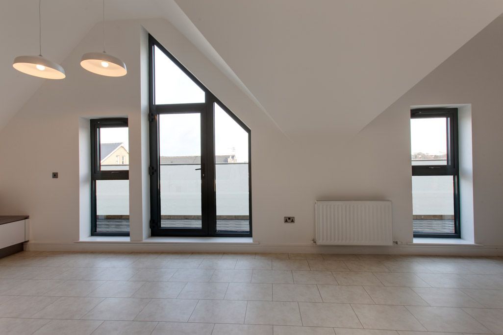 An empty room with a balcony and a lot of windows