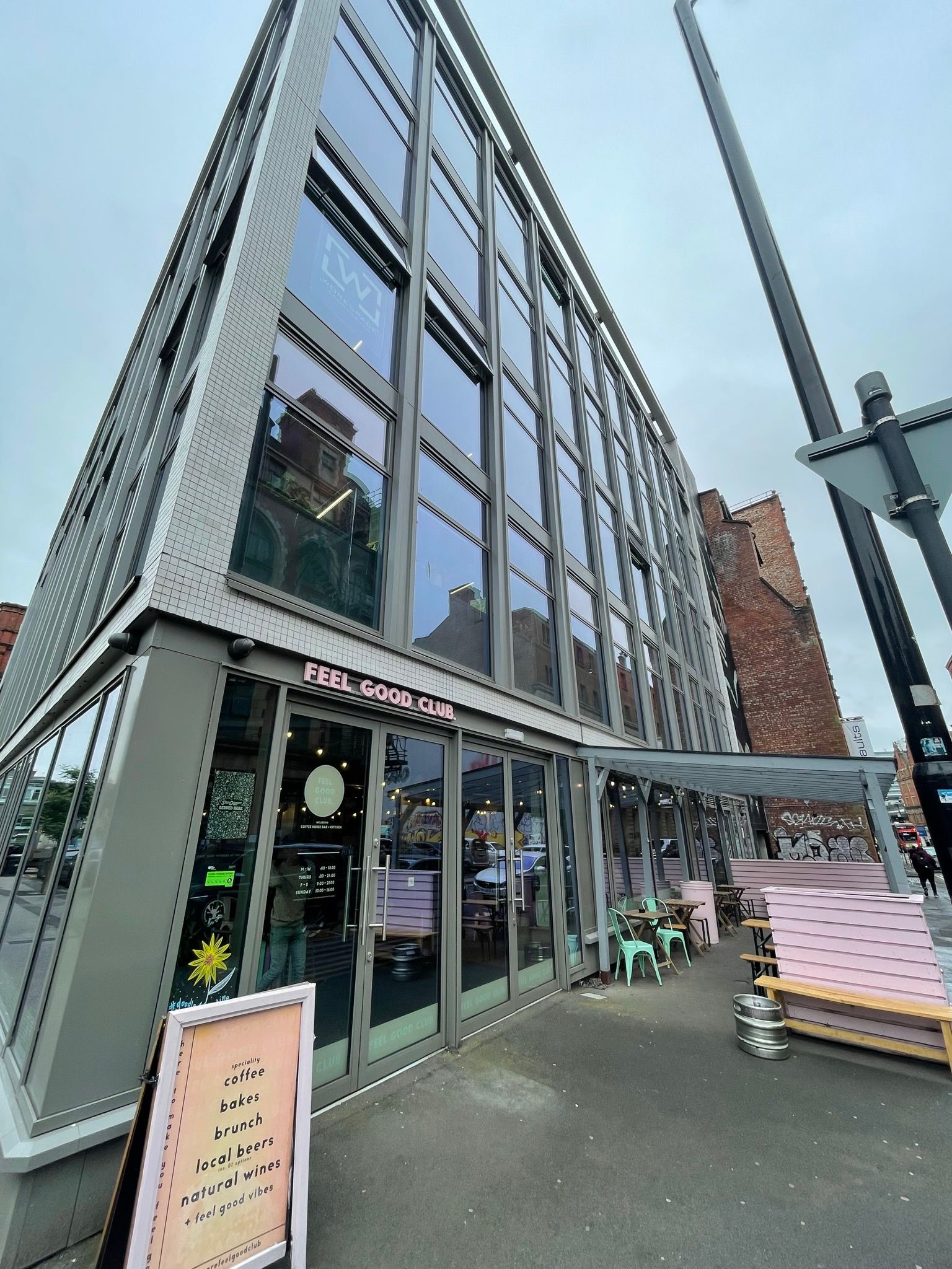 A large building with a lot of windows and tables outside.
