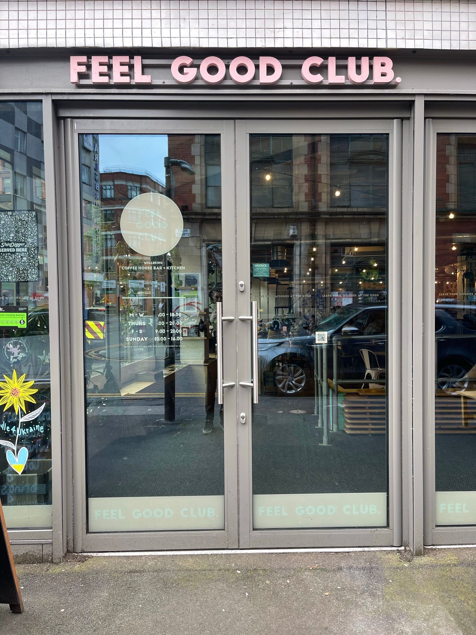 A store front with a sign that says `` feel good club ''.