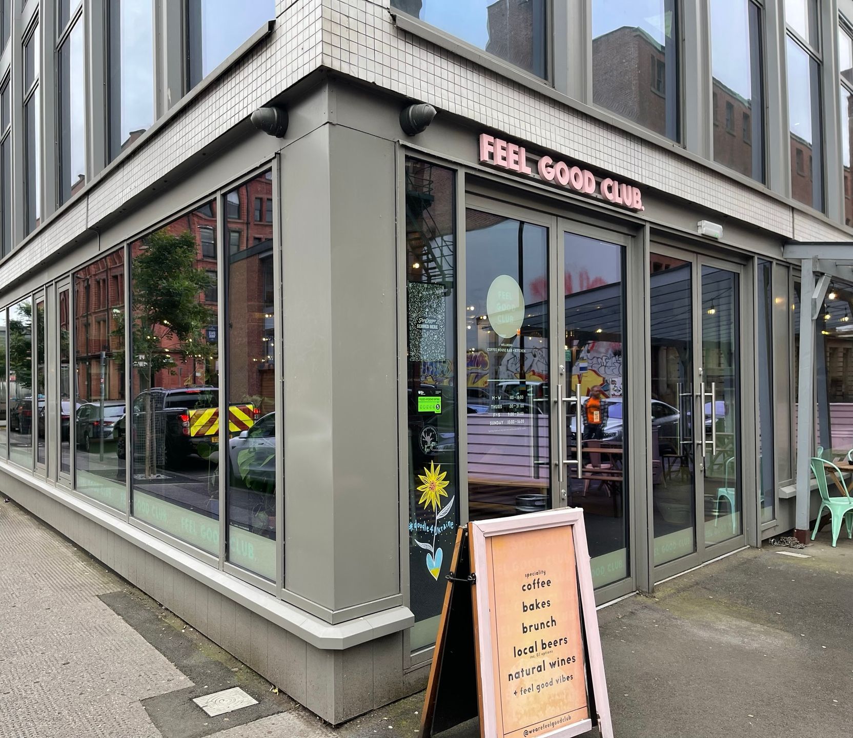 A restaurant with a sign in front of it that says `` feel good club ''.