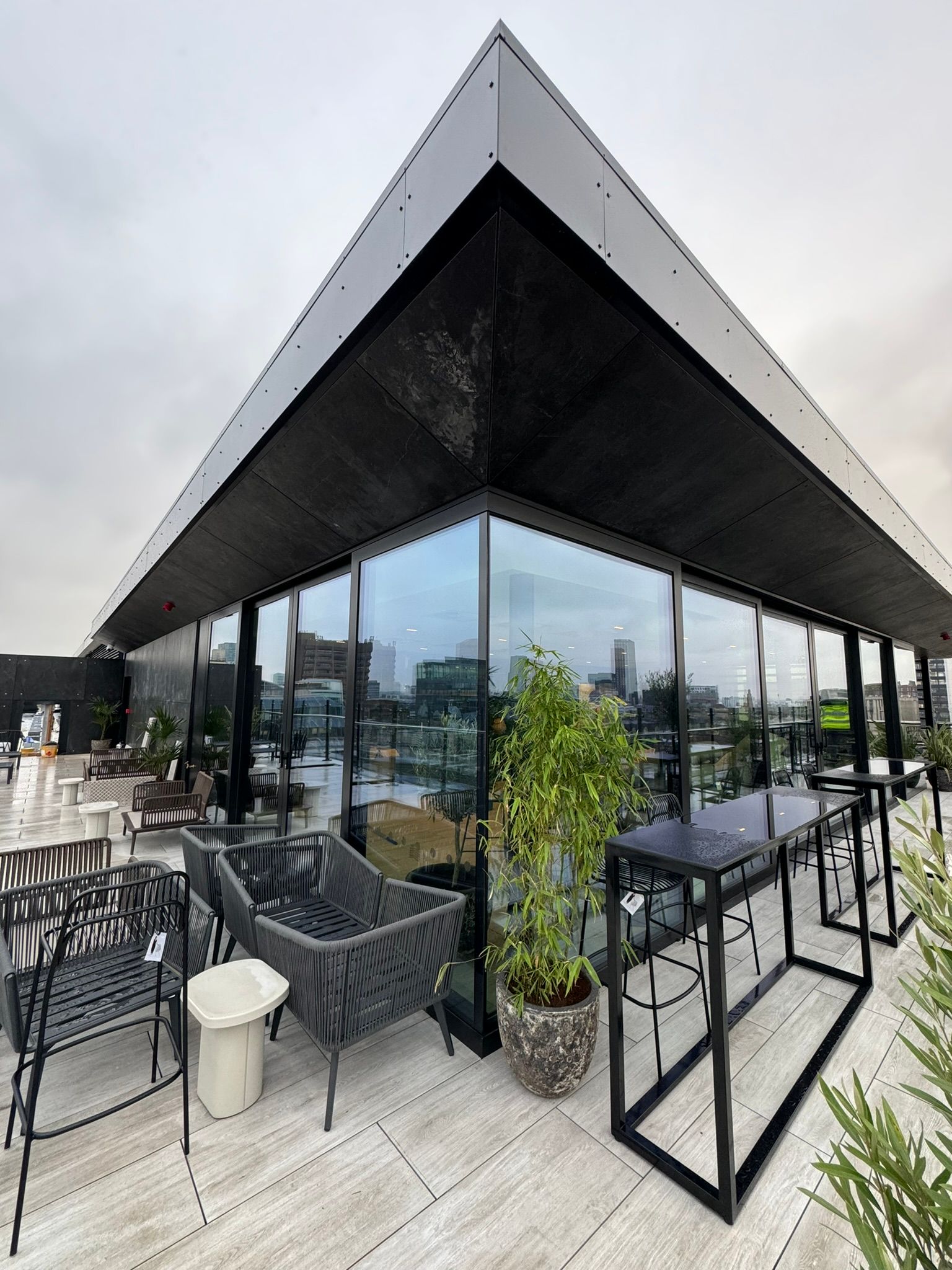 A large building with a lot of windows and furniture on the roof.