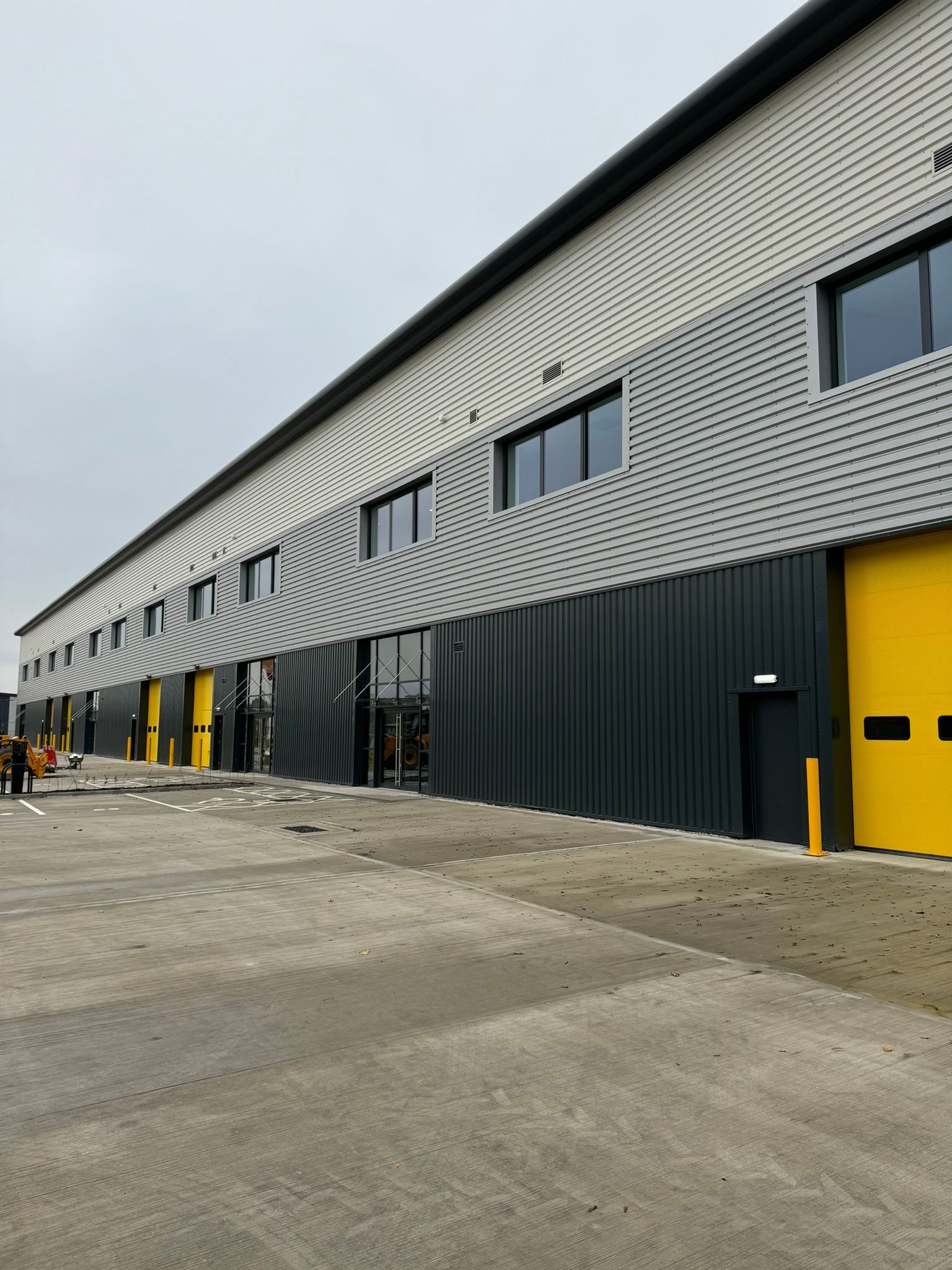 A large building with a lot of windows and yellow doors.