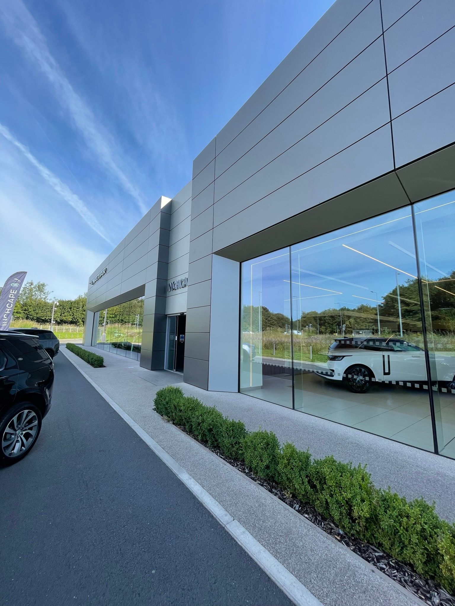 A car is parked in front of a car dealership
