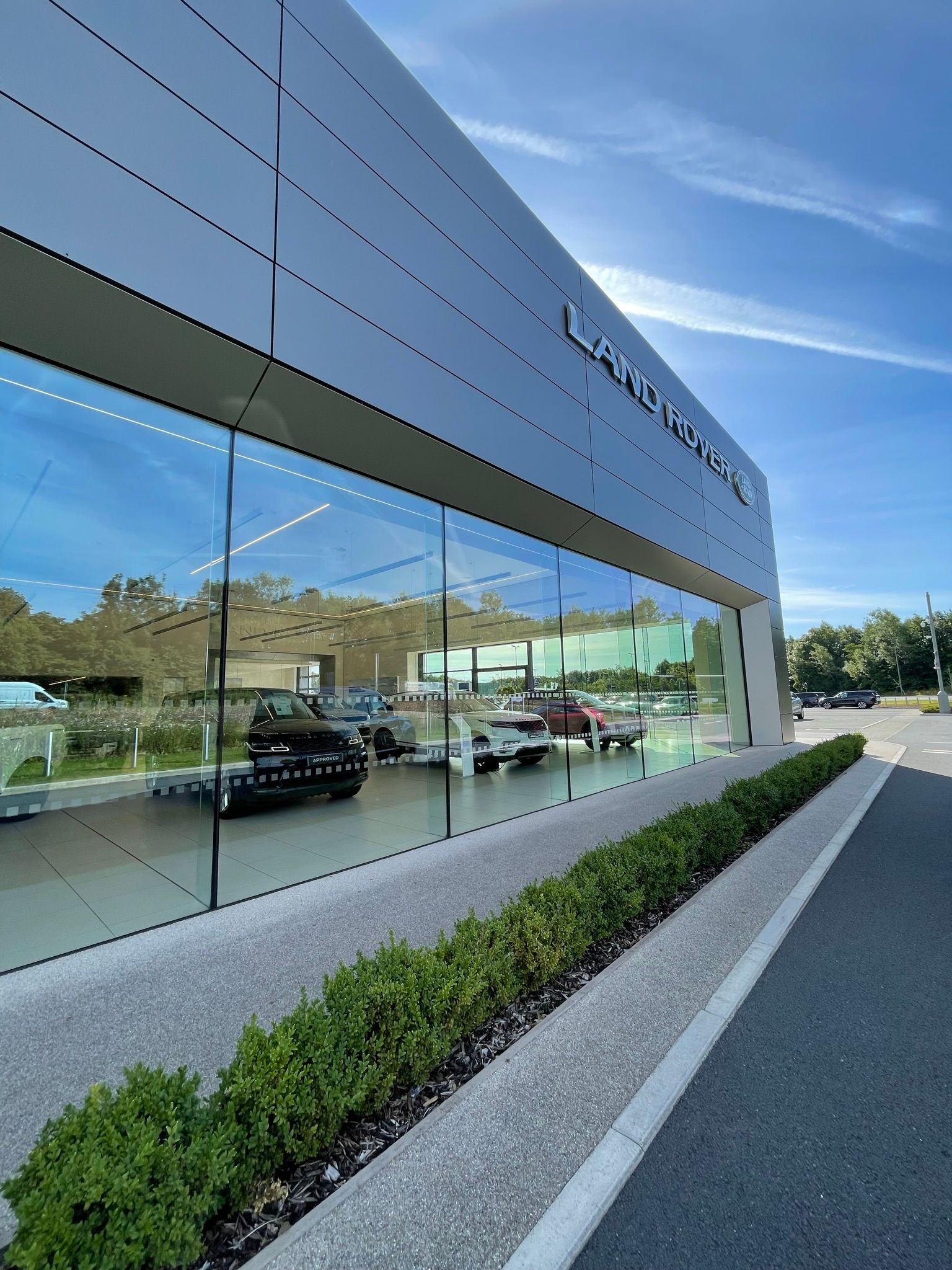 A car dealership with a lot of cars parked in front of it.