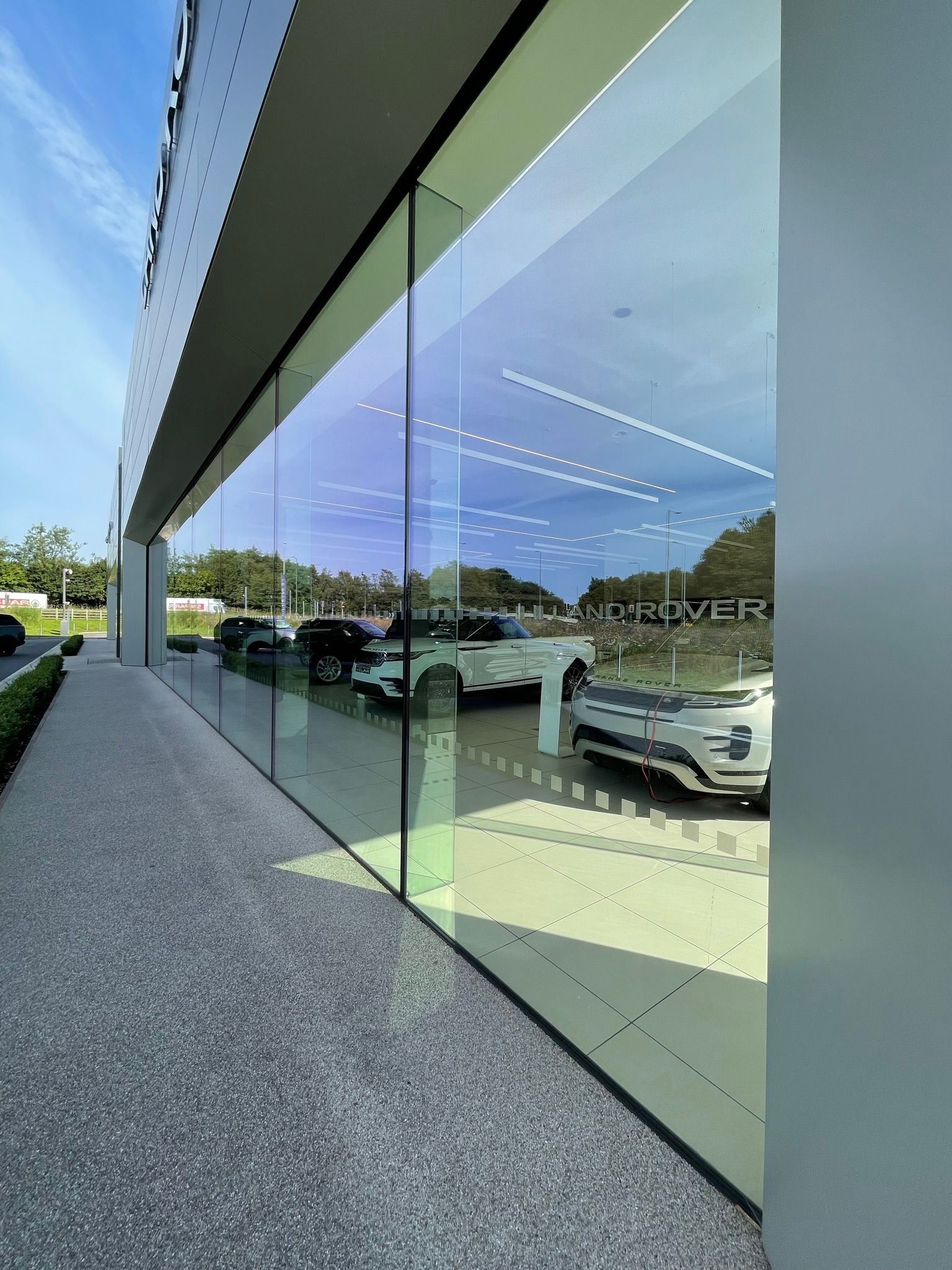 A car dealership with a lot of windows and cars parked in front of it.