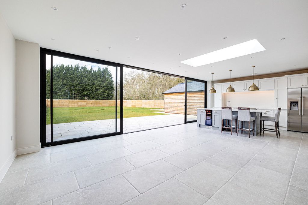 A large empty room with a dining table and chairs and a large window.