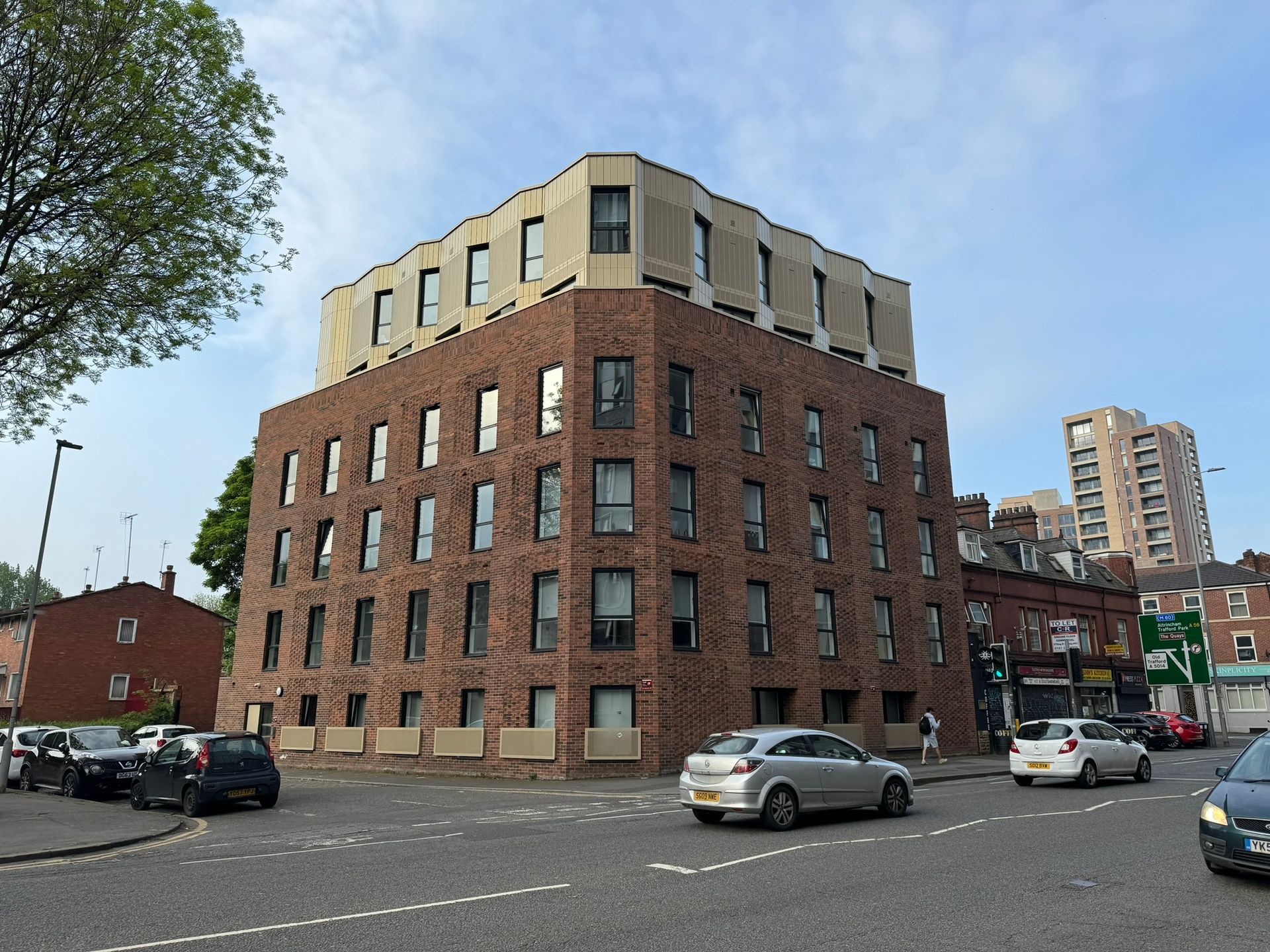 A large brick building with cars parked in front of it.
