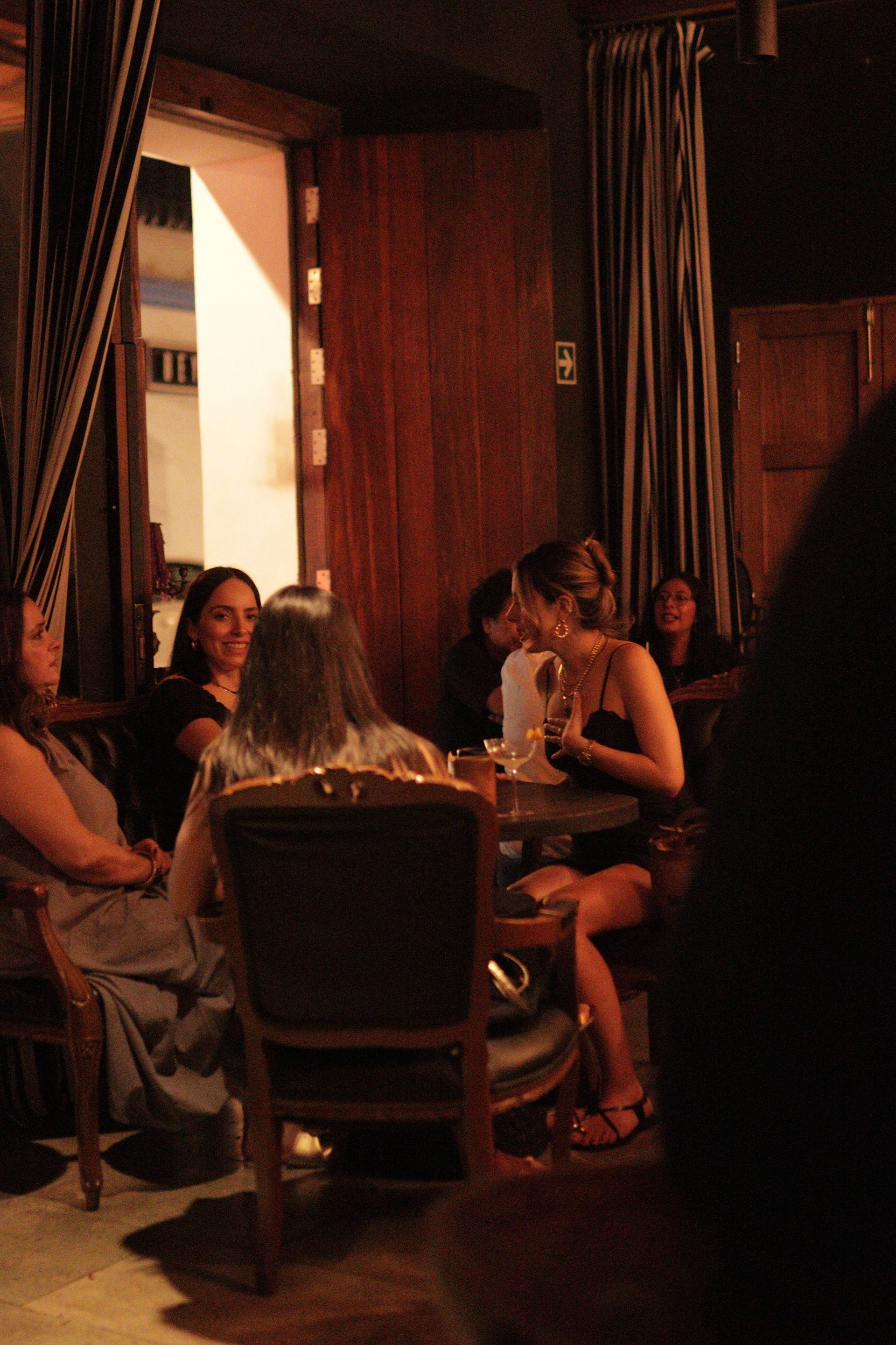 People dining at a dimly lit restaurant table in a cozy, wood-paneled room
