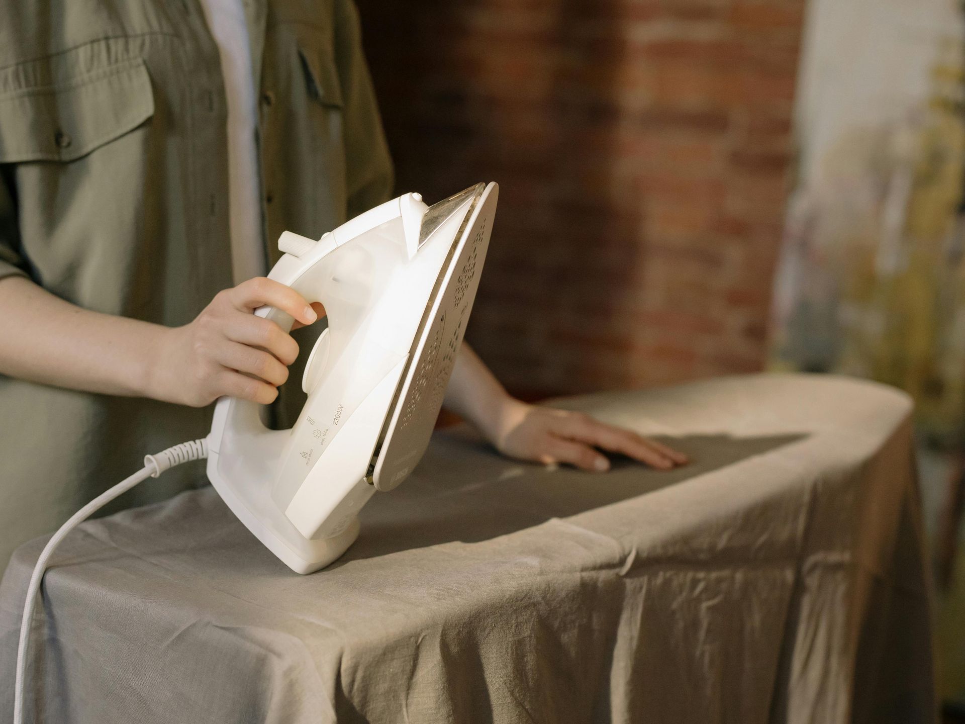 A person is ironing a piece of cloth on an ironing board.