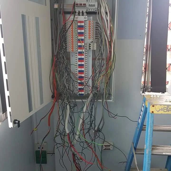 Electrical Wiring Panel With Tangled Wires, Open Door, Blue Ladder — Ionspark Electrical in Atherton, QLD