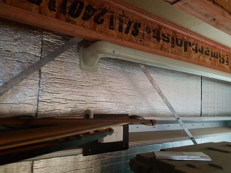 Fluorescent light fixture installed in a ceiling, with foil-faced insulation visible.— Ionspark Electrical in Atherton, QLD