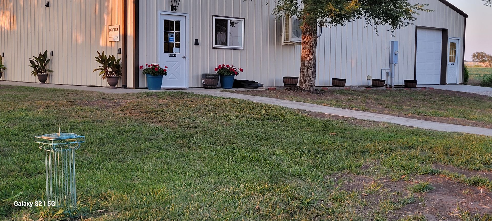 A large white building with a lot of grass in front of it.