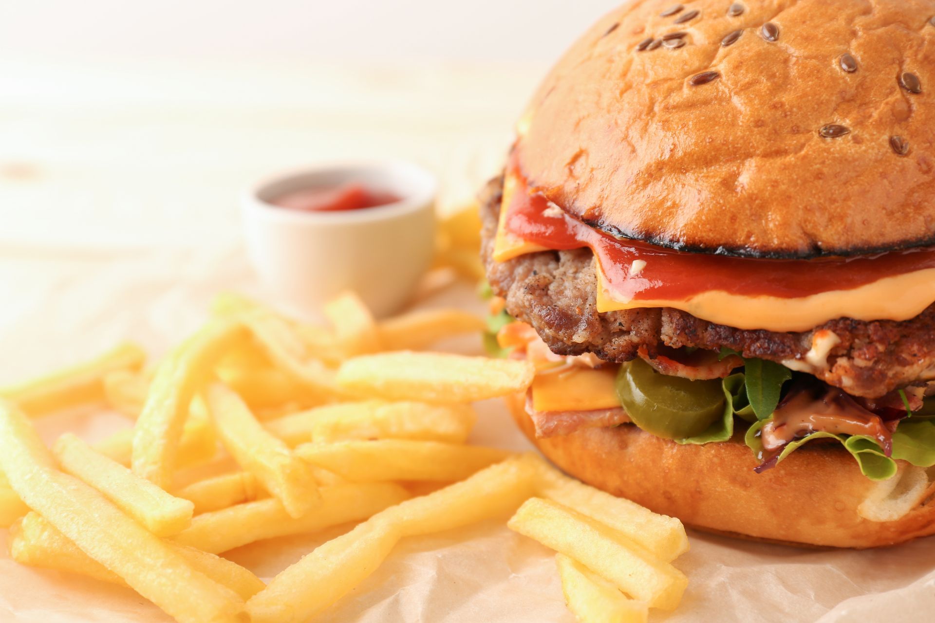 A close up of a hamburger and french fries on a table.