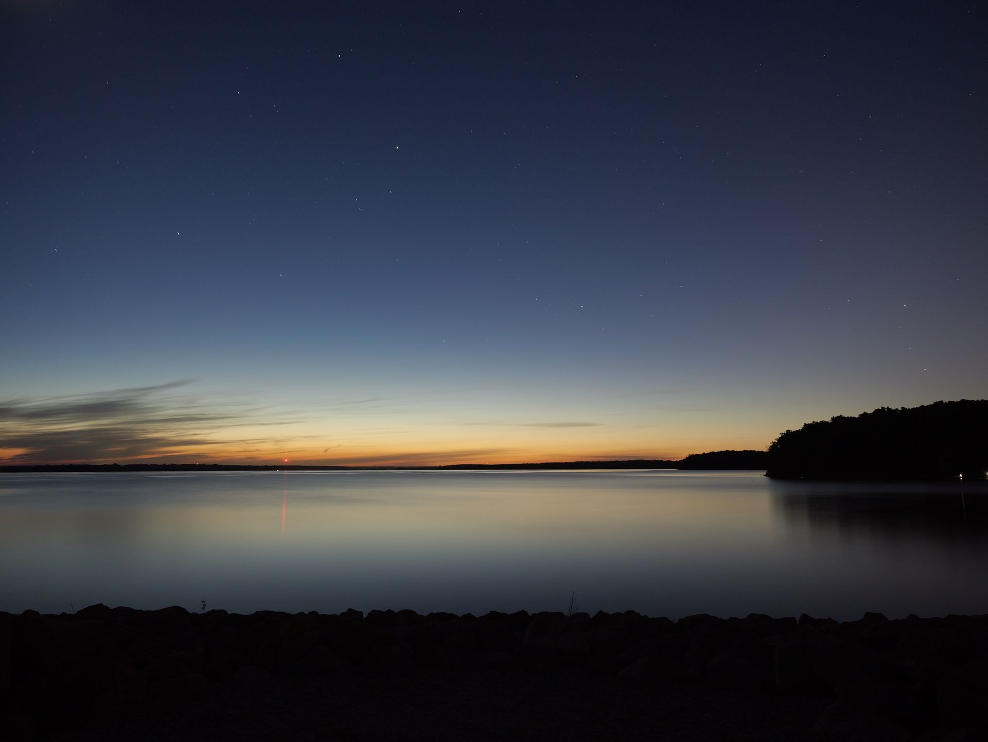 A large body of water with a sunset in the background