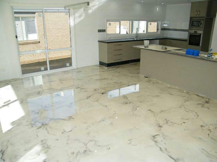 Modern empty kitchen with glossy marble floor, beige cabinets, and large sliding glass doors