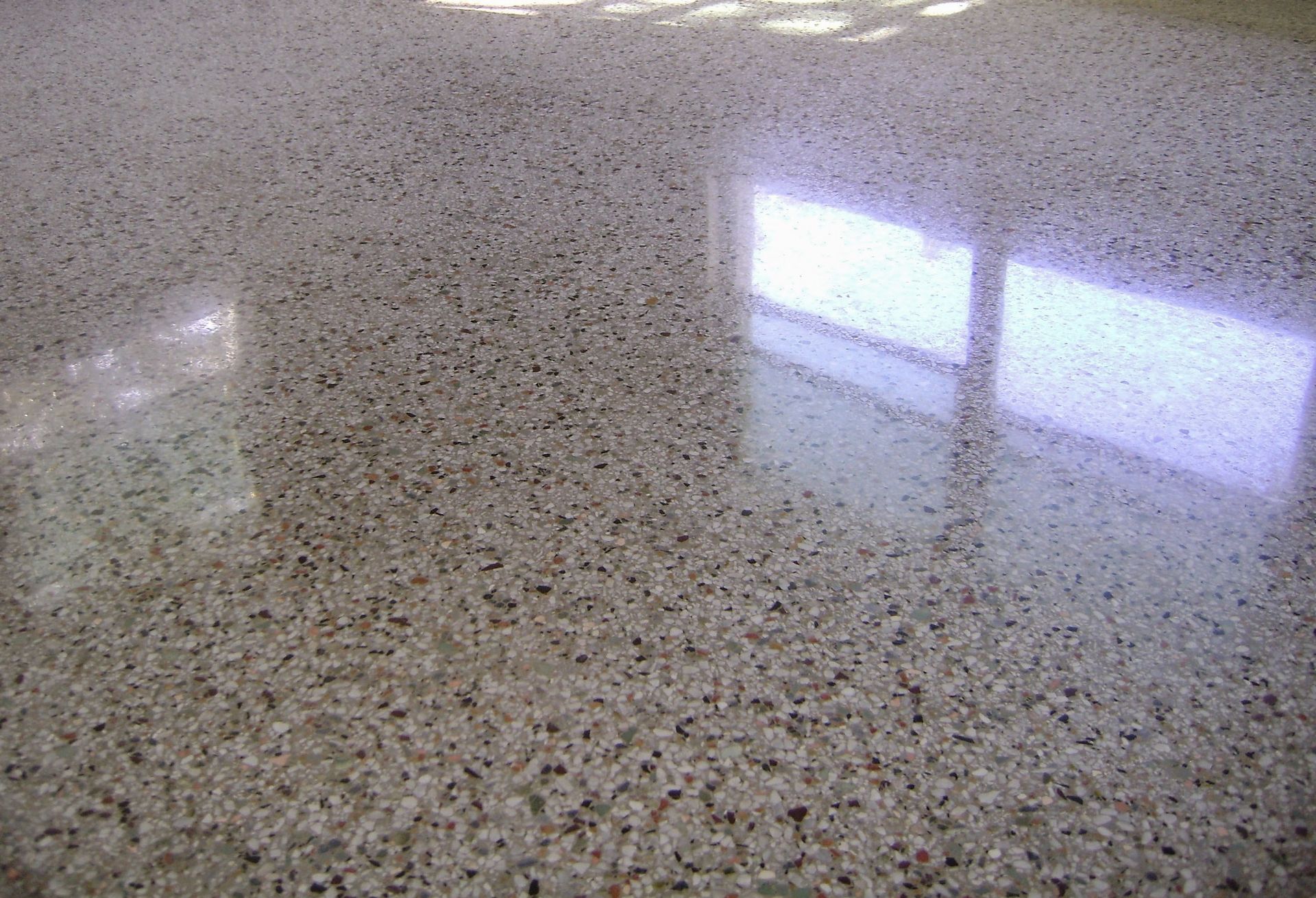 Polished speckled granite countertop reflecting window light
