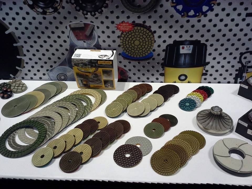 Assorted colorful woven coasters and circular mats displayed on a white table with product boxes behind them