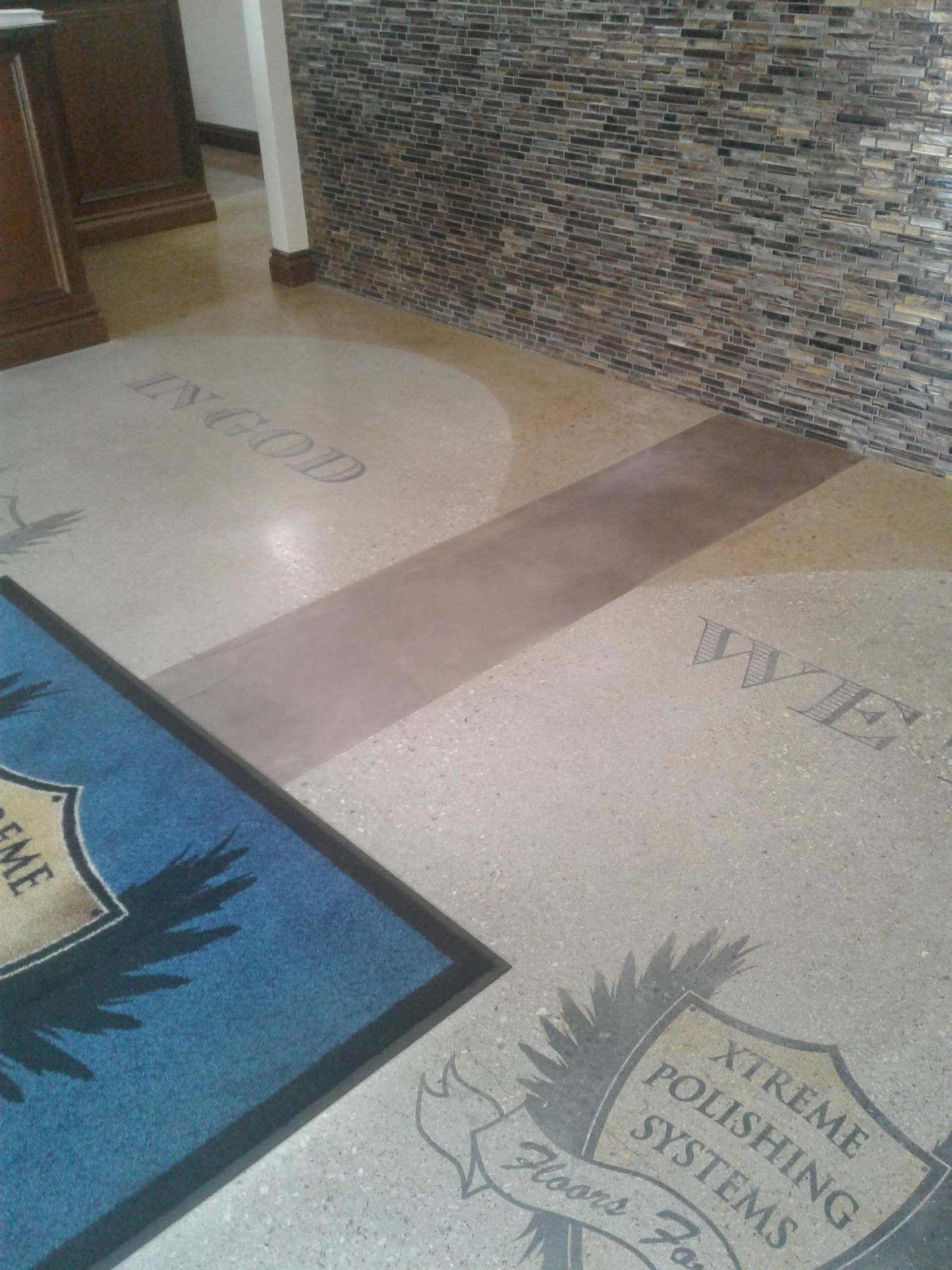 Hallway floor with decorative mat and stone-textured wall panels